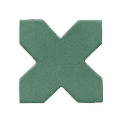 An X-shaped clay tile in muted green by Clay Imports, featuring a subtle grainy texture and soft, rounded edges.