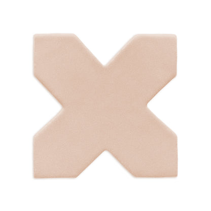 Light beige cross-shaped clay rattler by Clay Imports, with a matte, textured finish and rounded edges.
