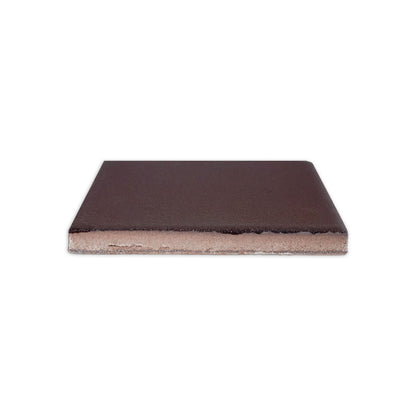 Dark brown 4.25x4.25 clay tile by Clay Imports, viewed from the side, revealing its textured top and exposed clay body.