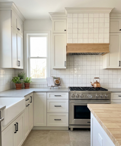 Drift Crackle Gloss 4x4 Solid Tile by Clay Imports, installed as a light-colored, glossy square grid kitchen backsplash.