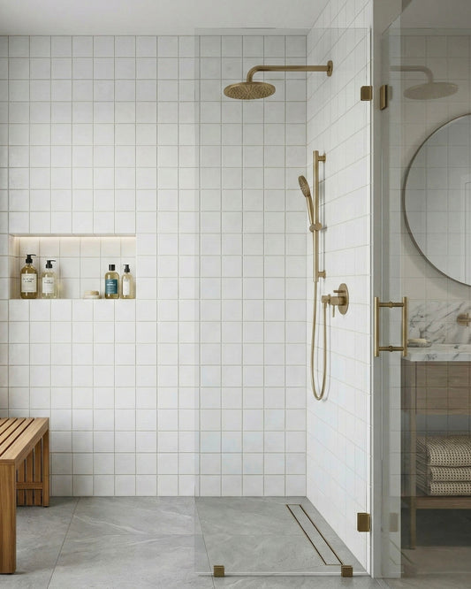White 4.25x4.25 inch clay tiles by Clay Imports lining a modern shower with brass fixtures and a wooden bench.