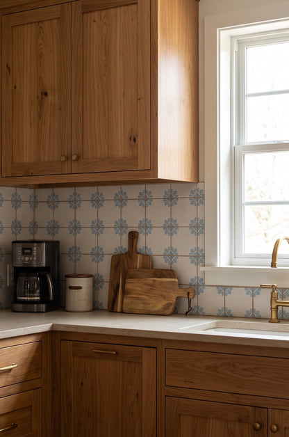 Cream and blue floral patterned Talavera tile by Clay Imports in kitchen backsplash, wooden cabinets, gold faucet, cutting boards, coffee maker