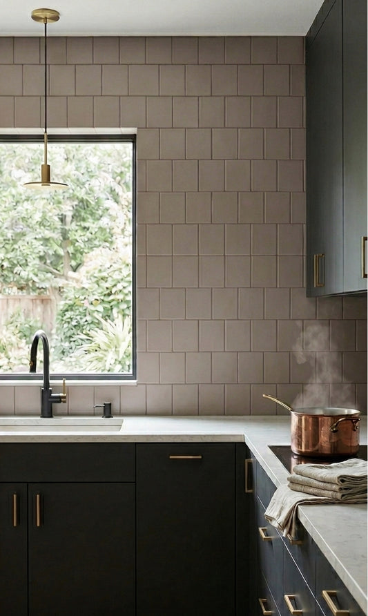 Matte coyote solid tile by Clay Imports, arranged in a stacked pattern as a kitchen backsplash with dark green cabinets and light countertops.