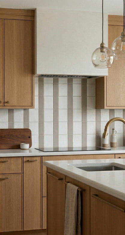 Light taupe Palo Santo Matte 2x5 solid tile by Clay Imports, installed as a vertical stripe kitchen backsplash with white tiles.