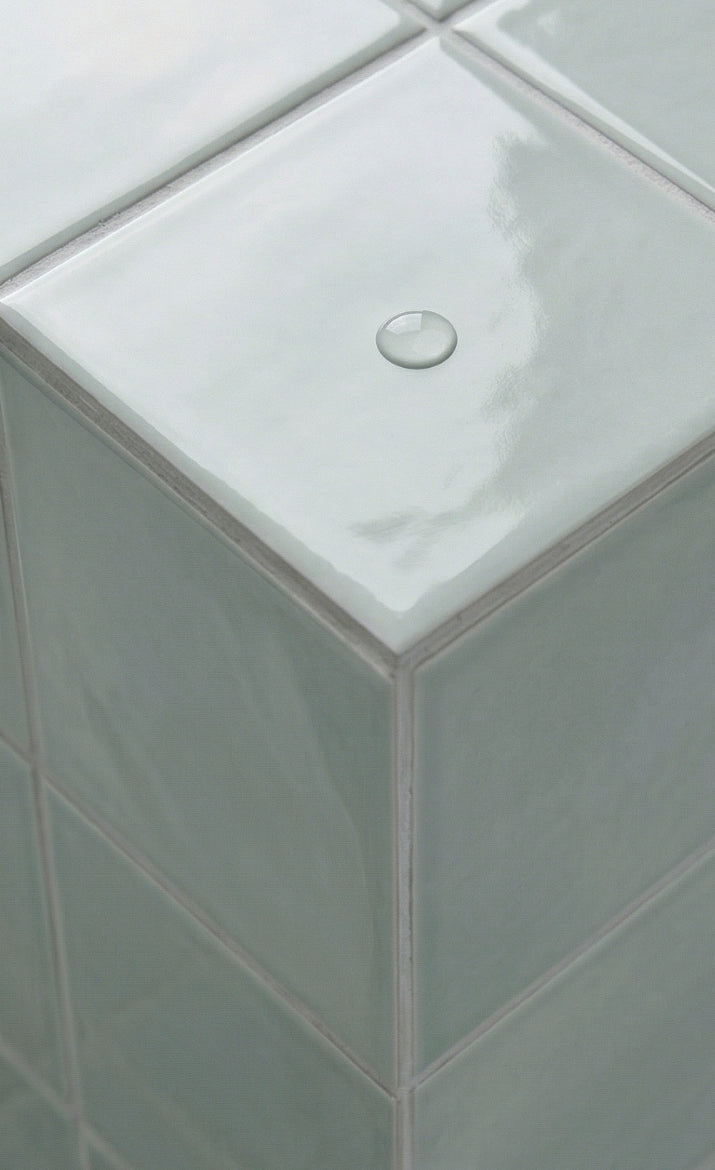 Seafoam green glossy solid tile by Clay Imports, showing a corner with a water droplet.