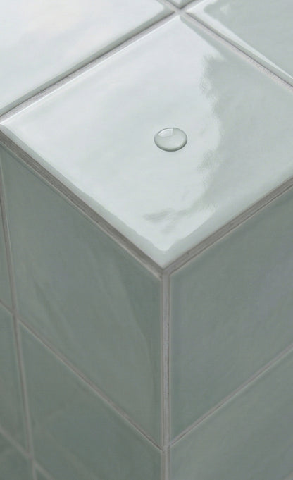 Seafoam green glossy solid tile by Clay Imports, showing a corner with a water droplet.
