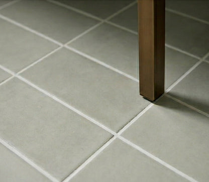 Muted green Agave 4x8 clay tiles by Clay Imports, with white grout lines and a bronze table leg.