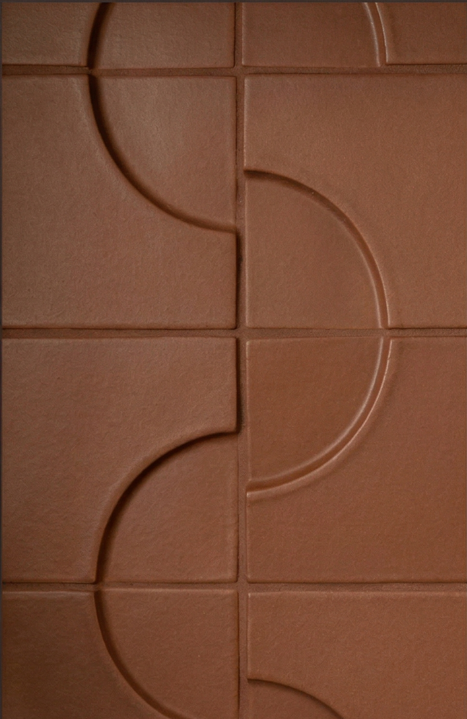 Mamey-colored clay tiles by Clay Imports with an embossed quarter-circle pattern creating a flowing design.