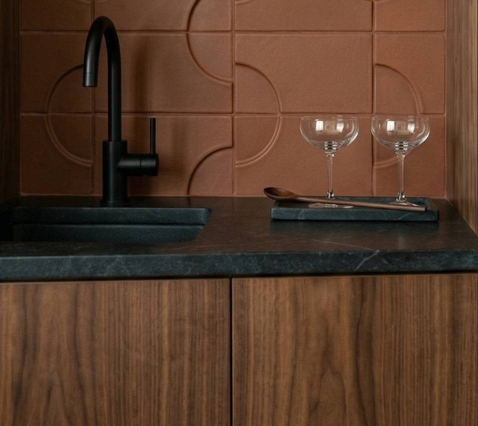 Mamey-colored clay tiles by Clay Imports featuring a raised circular pattern as a kitchen backsplash.