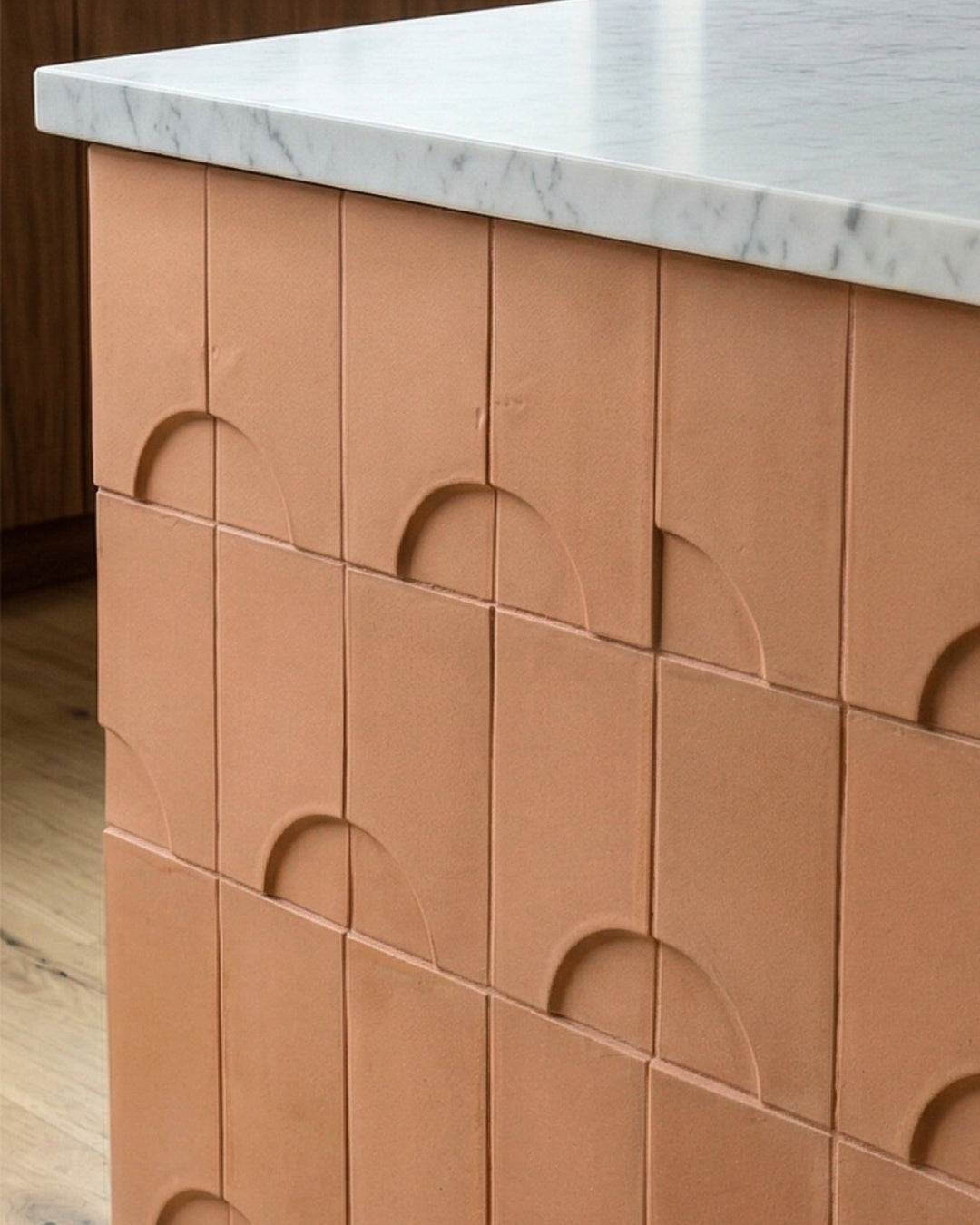 Terracotta tile by Clay Imports with a repetitive half-circle relief pattern on a kitchen island.