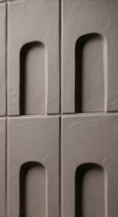 Brown clay tiles by Clay Imports featuring a repeated arched recess design, matte texture, and visible grout.