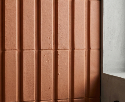 Terracotta Otero Mamey clay tiles by Clay Imports, featuring a vertical fluted pattern and water droplets.