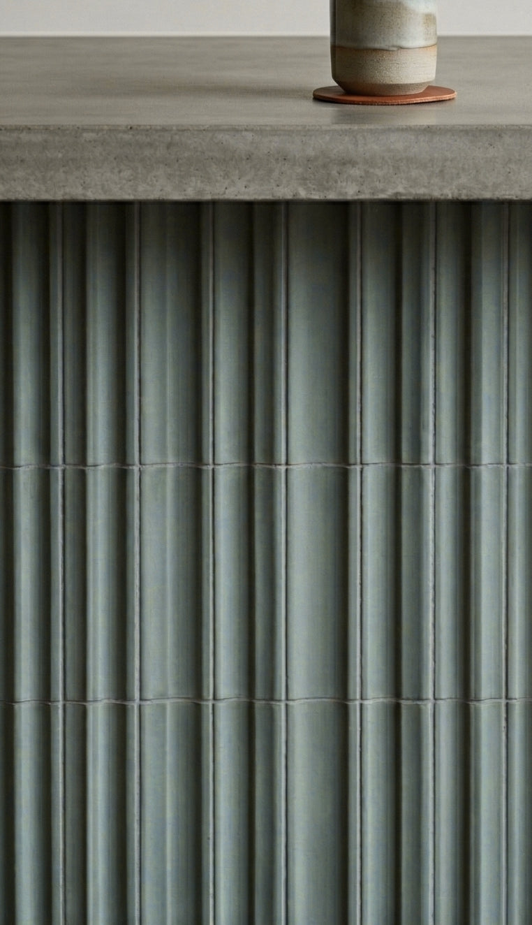 Valle Rucksack Green Clay Tiles by Clay Imports, featuring a fluted texture beneath a concrete countertop.
