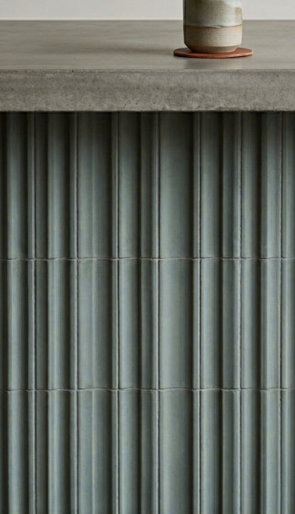 Valle Rucksack Green Clay Tiles by Clay Imports, featuring a fluted texture beneath a concrete countertop.