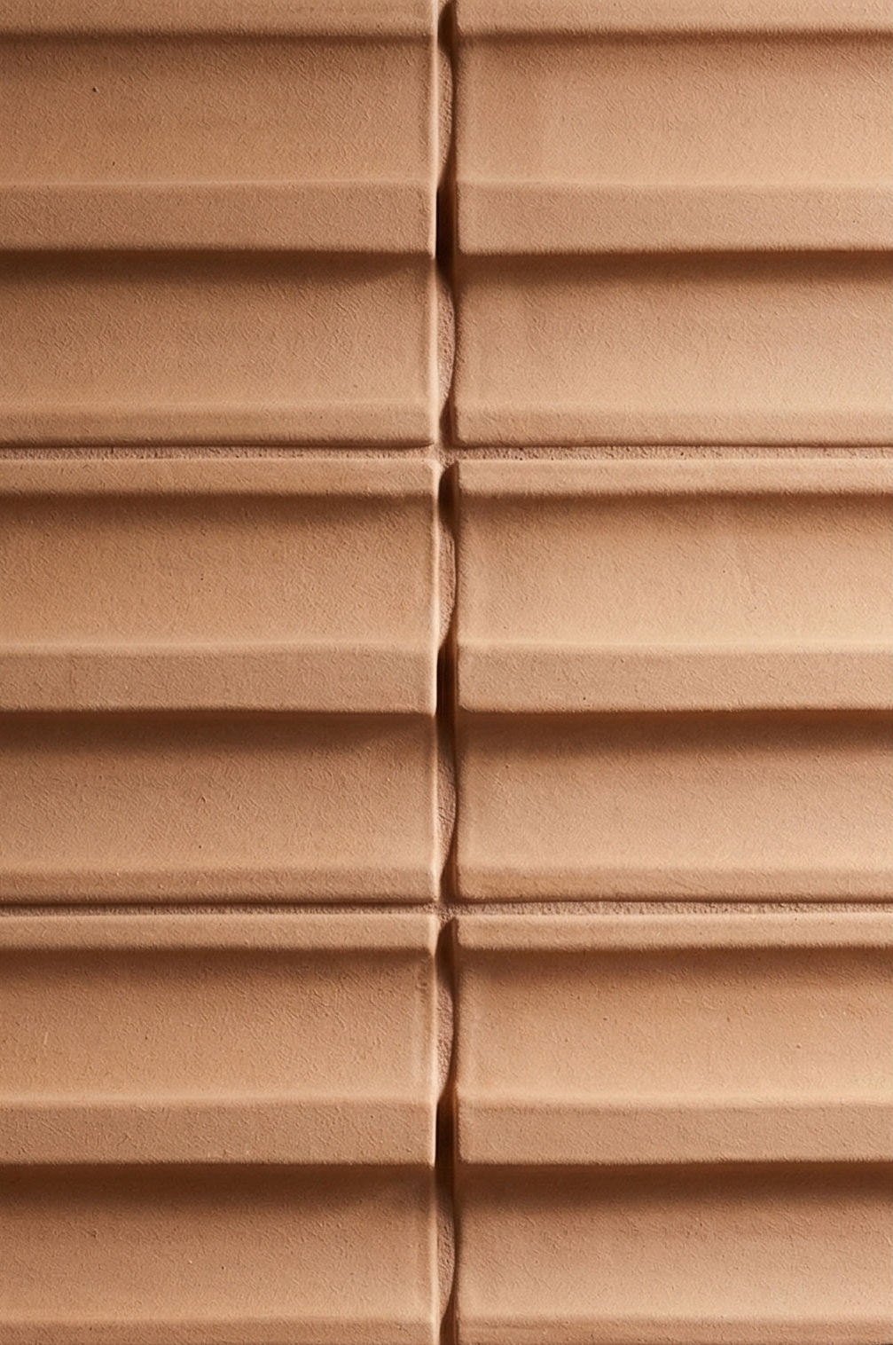 Terracotta ribbed clay tile by Clay Imports, with distinct horizontal ridges and textured surface.