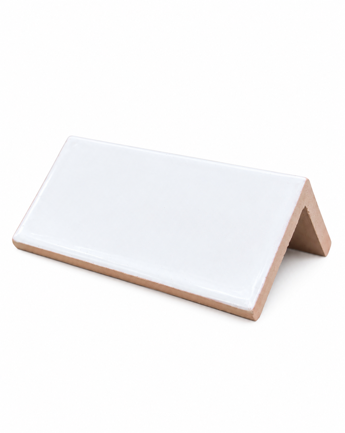 A glossy white glazed V-shaped corner tile rests on a clean white background.