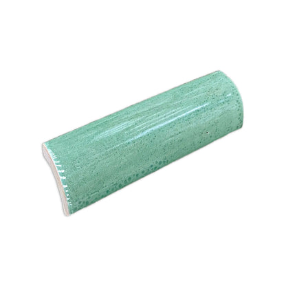 Jade green quarter round tile by Clay Imports, showing a glossy, bubbly surface from an angled view.