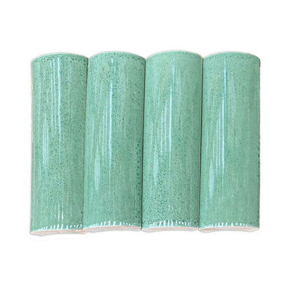Quarter Round Jade solid tile by Clay Imports, four green pieces with speckled, glossy glaze and rough unglazed bottoms.