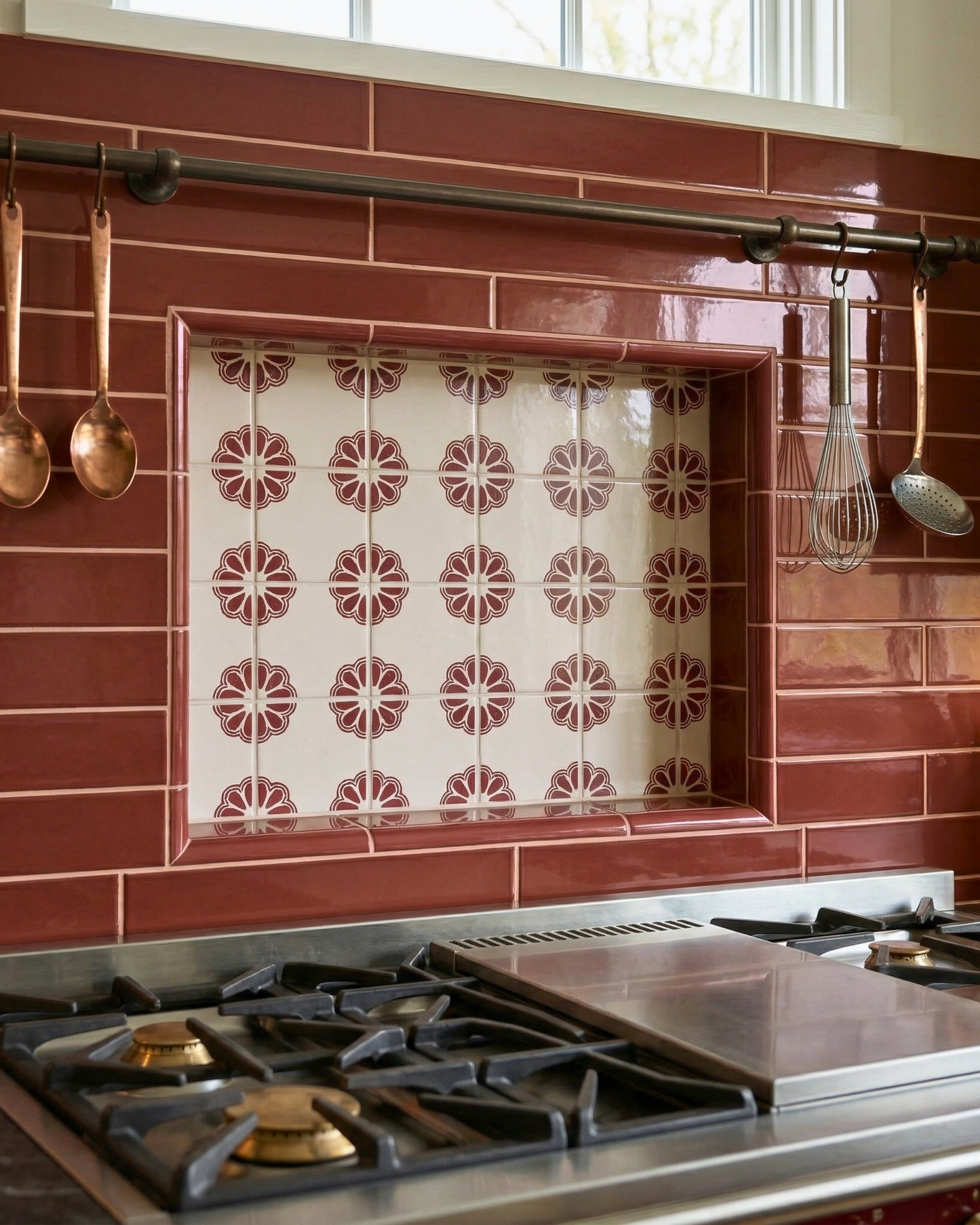 Talavera tile with an Oxblood Alamos pattern by Clay Imports Handmade Tile, featuring a repeating floral design on a light background, installed in a kitchen niche.