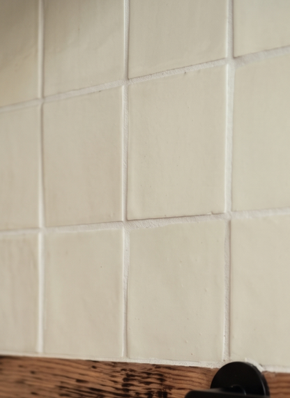 Cream square clay tiles from Clay Imports, featuring visible grout lines, subtle texture, and a wooden counter.