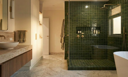 Glossy dark green 4x4 solid tiles by Clay Imports, forming a tiled shower wall and floor in a modern bathroom.