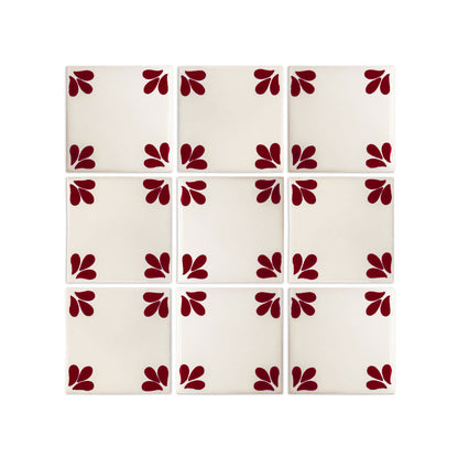 Oxblood Talavera tile by Clay Imports Handmade Tile, featuring three petal-like shapes in each corner, arranged in a 3x3 grid on an off-white background.