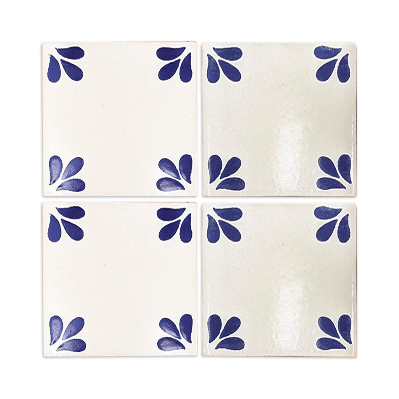 Four white Talavera tiles by Clay Imports Handmade Tile, each with blue leaf patterns in the corners.