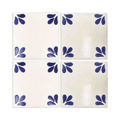 Four white Talavera tiles by Clay Imports Handmade Tile, each with blue leaf patterns in the corners.