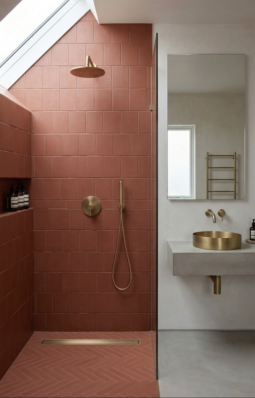 Reddish-brown lava rock matte solid tiles by Clay Imports, stacked vertically on shower walls and laid in a herringbone pattern on the floor.
