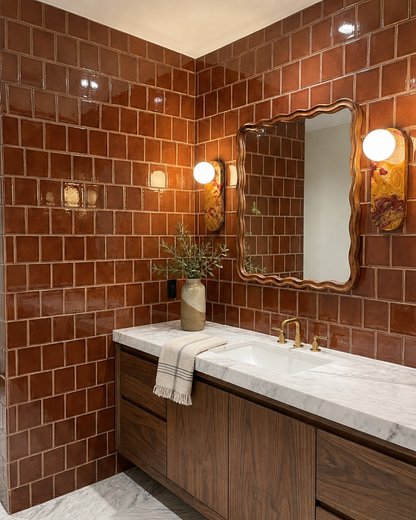 Tamarindo Gloss solid tile by Clay Imports in a subway pattern on a modern bathroom wall.