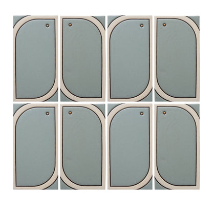 Eight light blue-green modular tiles by Clay Imports, with off-white curved frames and small brass studs, arranged in a grid.