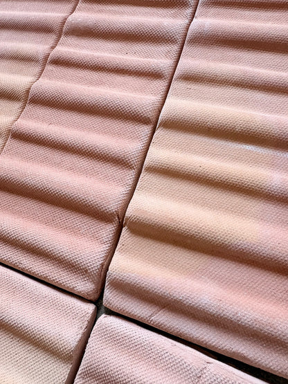 Terracotta matte sealed 3D hatch tiles by Clay Imports, arranged in a bundle with wavy, granular textures.