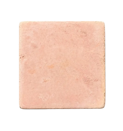 A single square terracotta tile rests isolated on a white background, displaying a warm, earthy hue and a naturally textured surface.