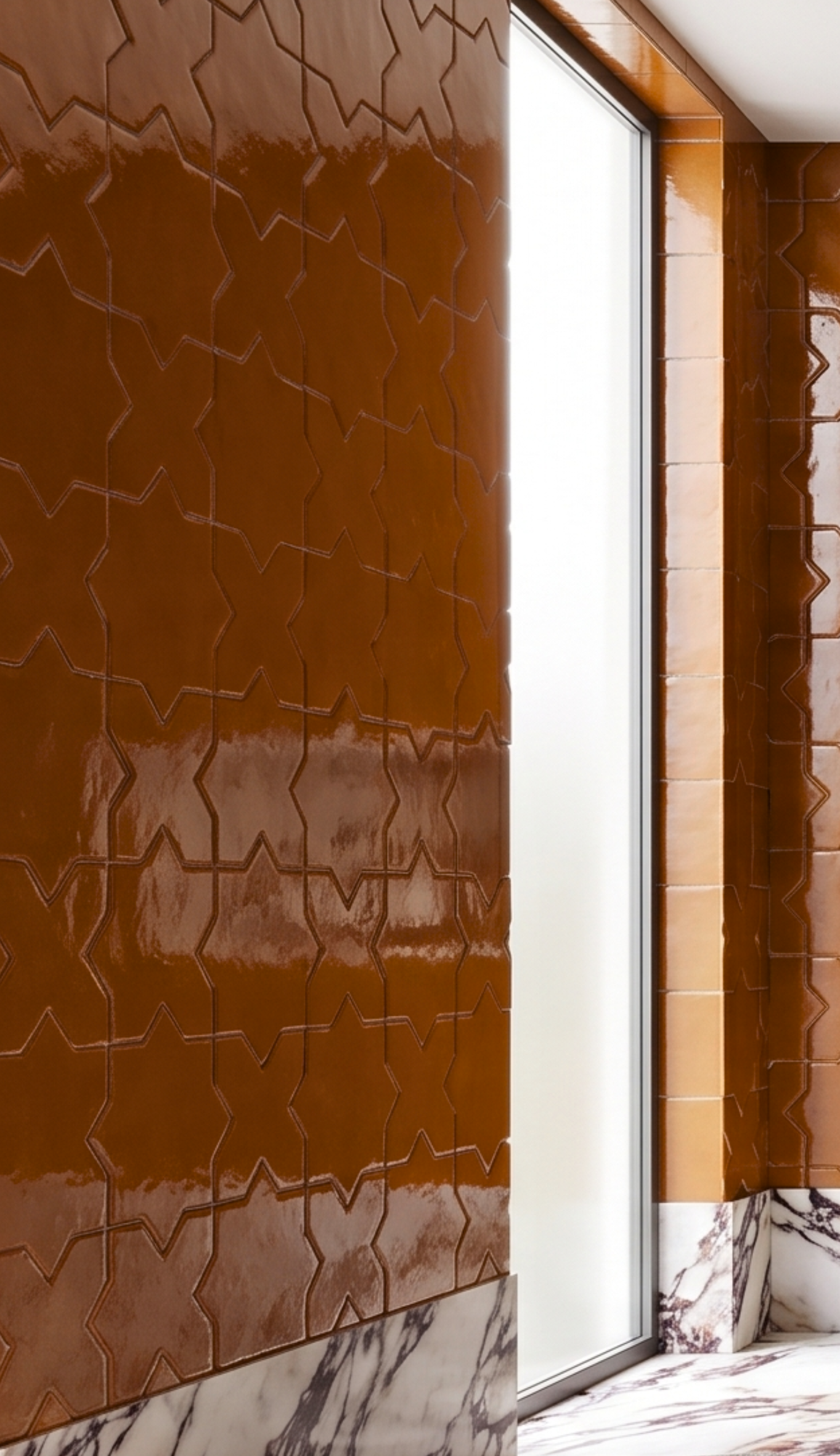 Glossy brown Cajeta Star & Cross 6 solid tile by Clay Imports with a geometric star and cross pattern, alongside white marble.