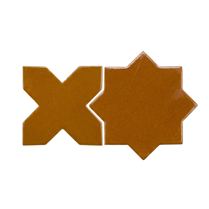 Glossy Cajeta brown star and cross solid tiles by Clay Imports, displayed side by side.