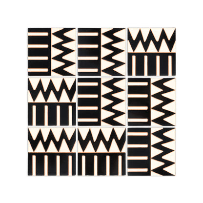 Black and off-white hand-painted tiles by Clay Imports, arranged in a grid with geometric zigzags and bar patterns.