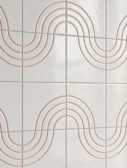 White relief tiles by Clay Imports with a repeating wavy pattern of copper-toned concentric lines on a glossy surface.