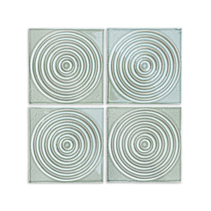 Four square arctic gloss ceramic tiles by Clay Imports with a raised concentric circle pattern, arranged in a grid.