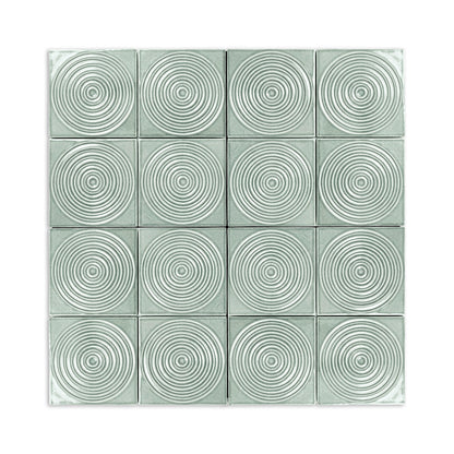 Light grey-green glossy ceramic tiles by Clay Imports, each with a raised concentric circle pattern in a 4x4 grid.