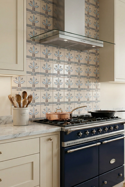Cream relief pattern tile by Clay Imports with repeating stylized blue leaf motifs and geometric lines on a kitchen backsplash.