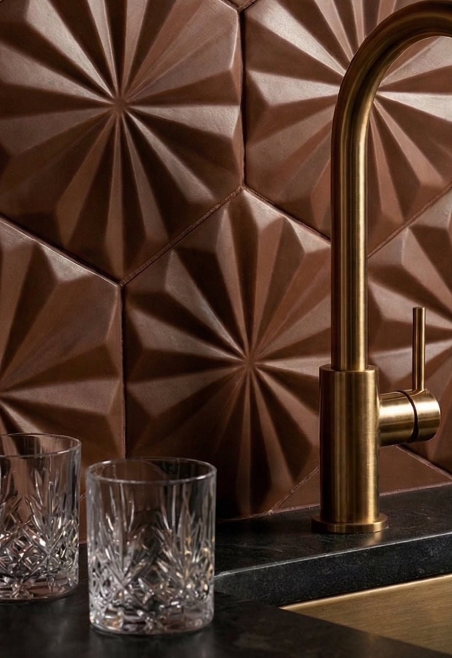 Brown hexagonal solid tile by Clay Imports with a raised geometric starburst pattern, used as a kitchen backsplash.