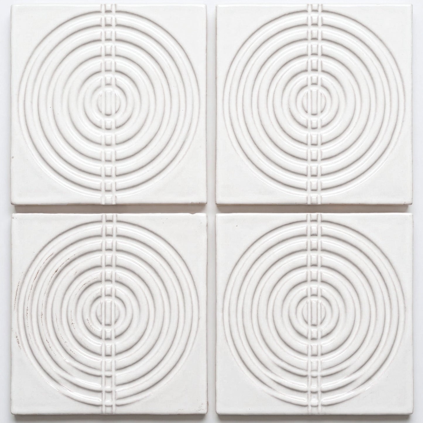 White Perla Gloss ceramic tile by Clay Imports with raised concentric circles and a central vertical square pattern.