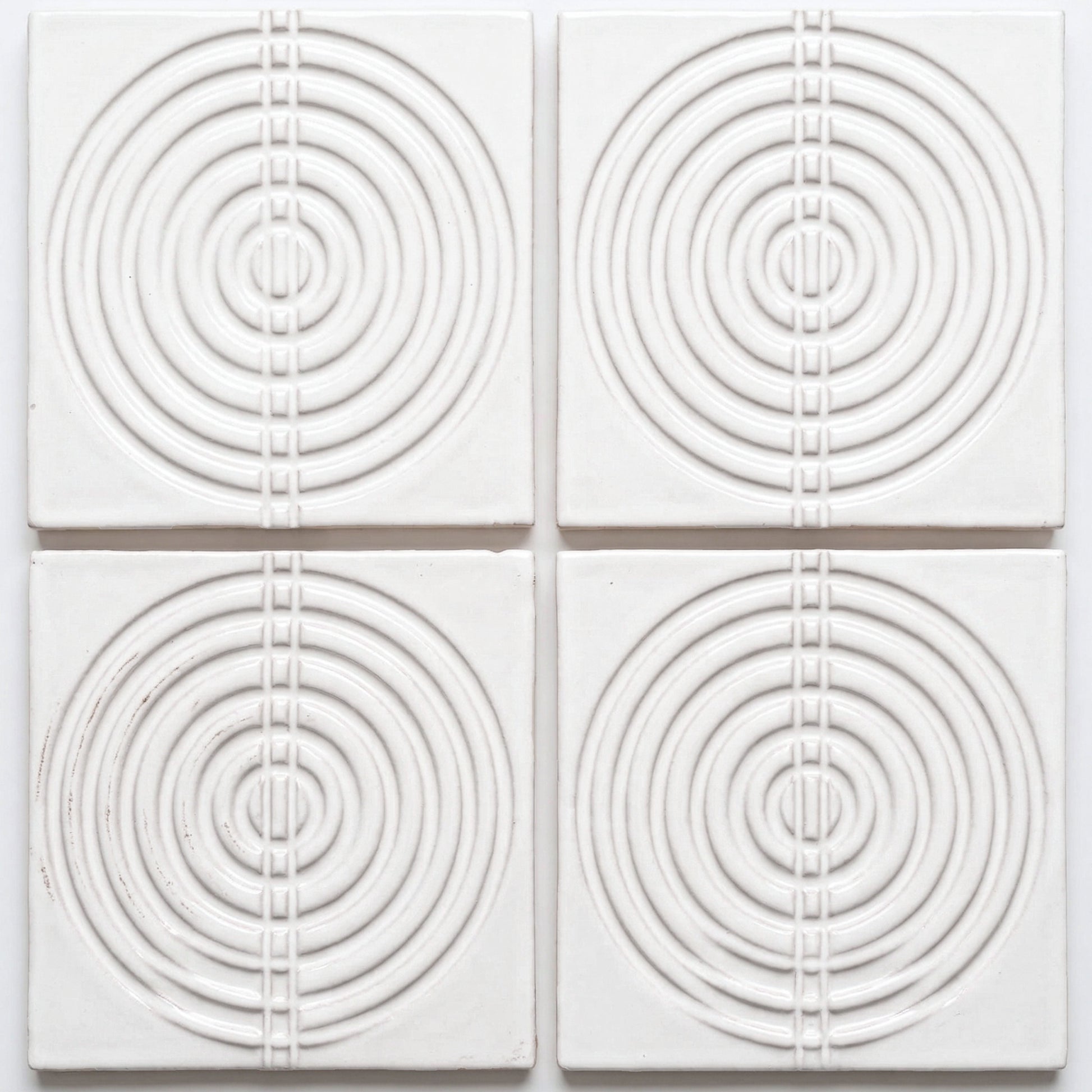 White Perla Gloss ceramic tile by Clay Imports with raised concentric circles and a central vertical square pattern.