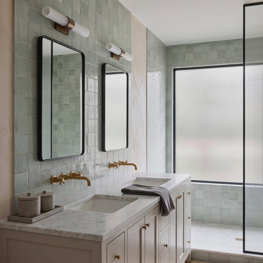 Light blue glossy 6x6 ceramic tile by Clay Imports in modern bathroom with marble vanity and black-framed mirrors