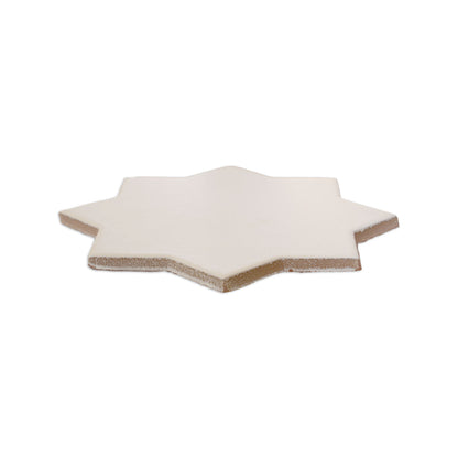 Vanilla 8-point star solid tile by Clay Imports with smooth matte surface and rough edges.