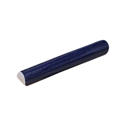 Dark blue pencil liner tile by Clay Imports, with a semi-circular profile and a light, flat end, angled on white.