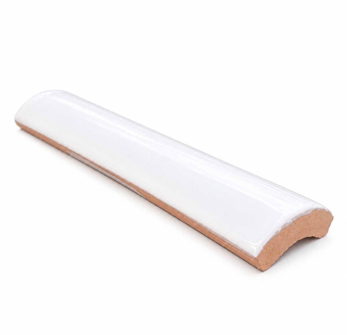 A glossy white glazed ceramic quarter round tile rests on a plain white background, showcasing its curved surface and terracotta base.