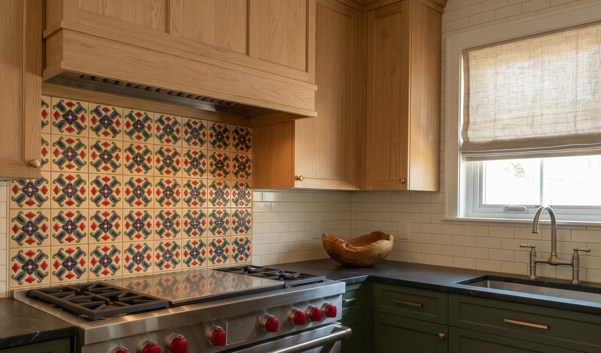 A modern kitchen features a stainless steel range stove beneath a decorative patterned tile backsplash, natural wood upper cabinets, and dark green lower cabinets.
