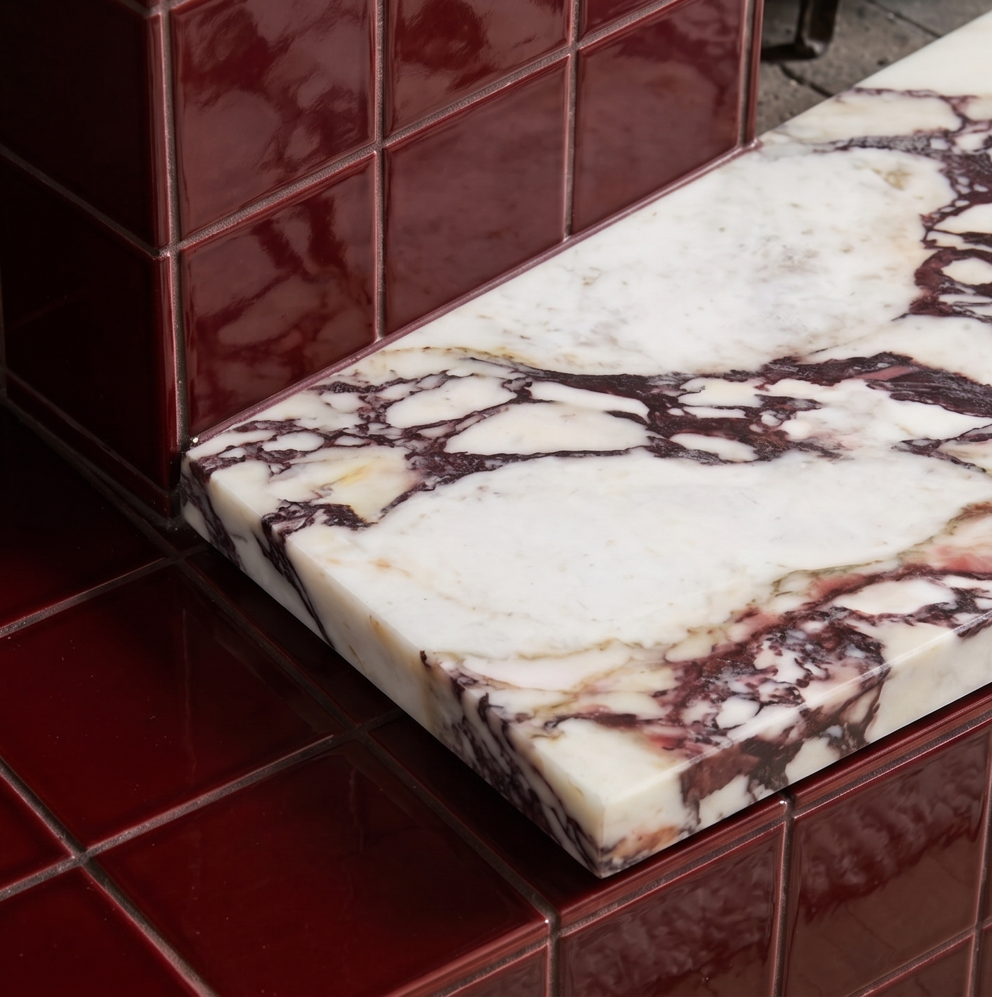 Glossy oxblood clay tiles by Clay Imports in a square pattern, with a white and purple-veined marble slab.