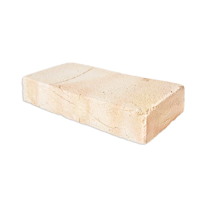 A rectangular light beige stone or concrete block with visible texture and a few natural cracks, isolated on a white background.